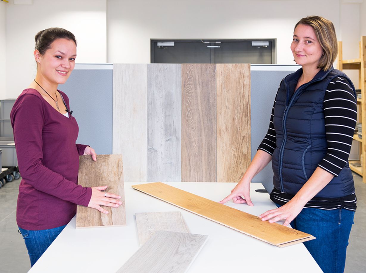 Twee werknemers tonen verschillende houtlook tegels