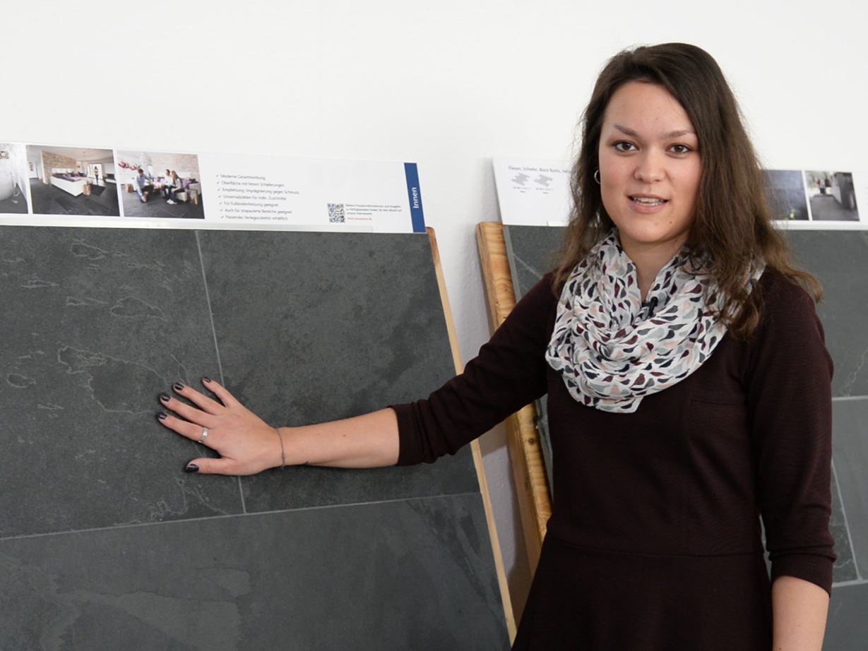 Werknemer staat voor voorbeeldpanelen van leisteen