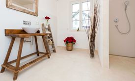 Moderne badkamer met houten meubels en lichtgekleurde kalkstenen tegels