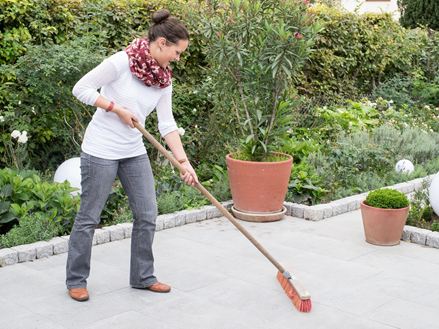 Vrouw maakt graniet grijs terras schoon