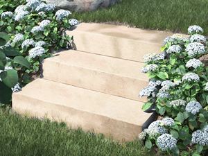 Hoogwaardige look met topfuncties Muurblokken kalksteen Camino Sand met bloemen en struiken