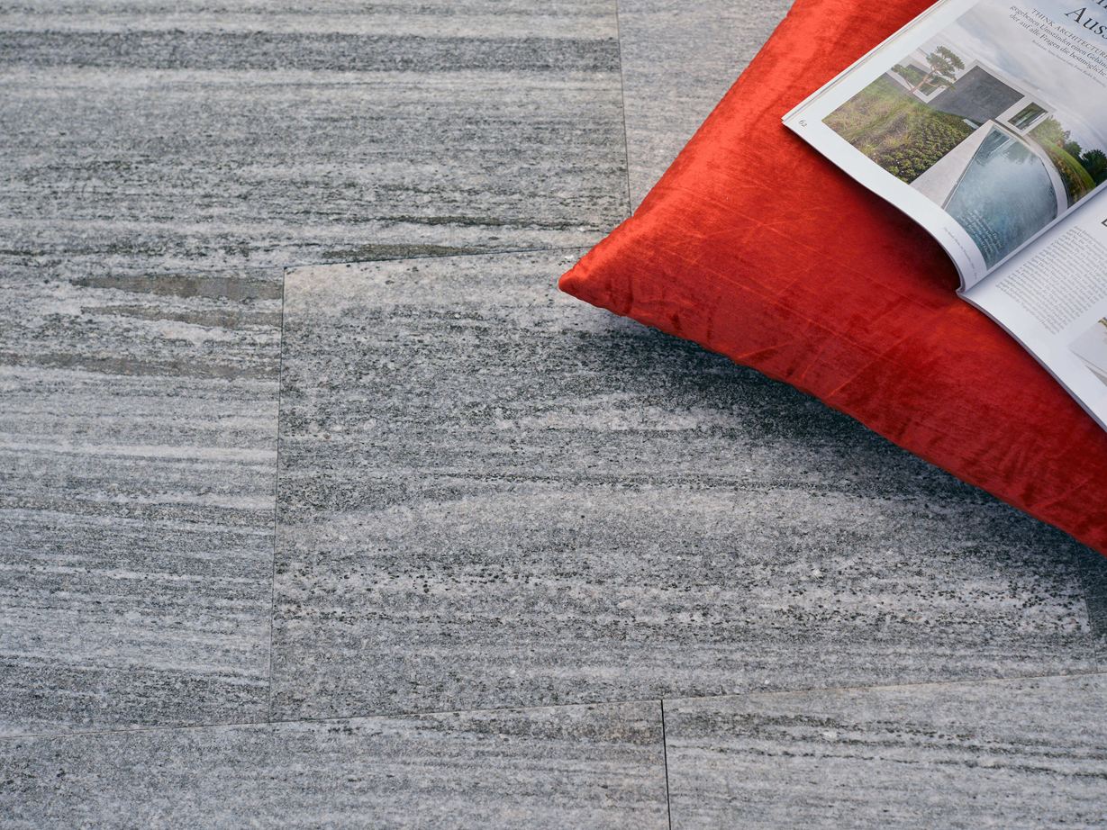 Urban Grey Line gneisplaten met oranje kussen en tijdschrift