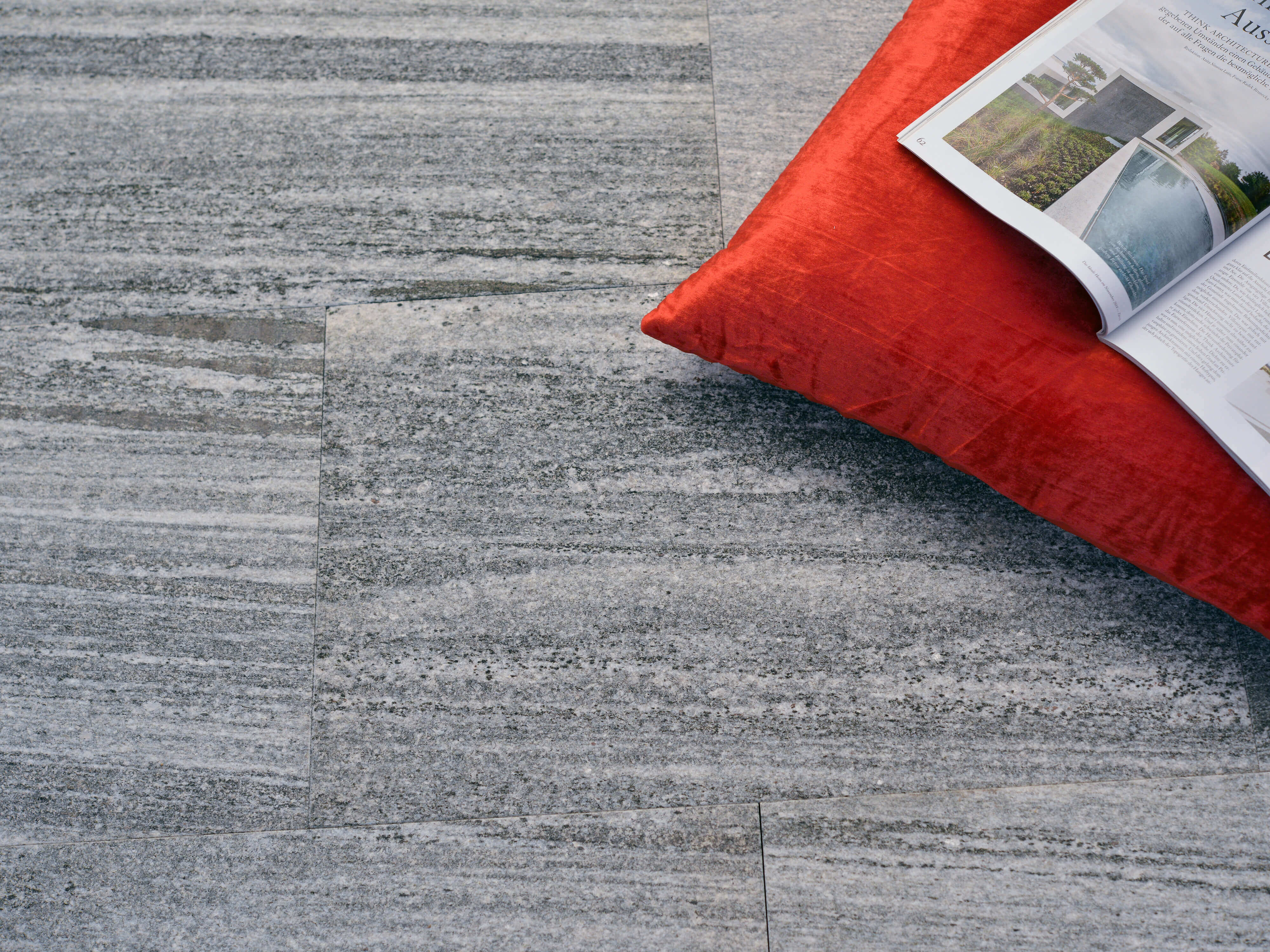 Urban Grey Line gneisplaten met oranje kussen en tijdschrift
