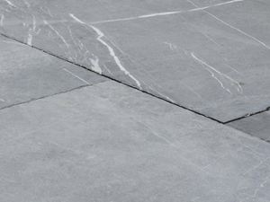 Het gebruikte uiterlijk maakt de hardsteen uniek. Close-up van platen gemaakt van kalksteen uit de Azur hardsteen, witte aders zijn zichtbaar in de lichtgrijze tint van de natuursteen.