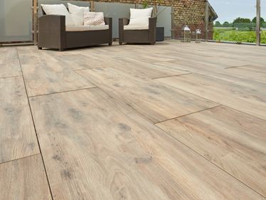 Terras met modern rotanmeubilair en houtlook Canada Lodge terras vanuit kikkerperspectief