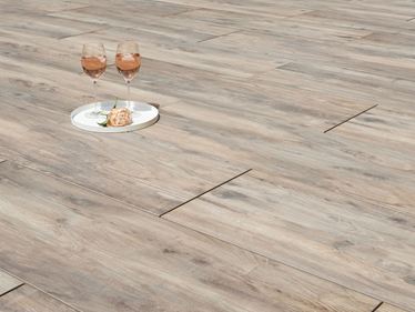 Twee wijnranken en een bloem op houtlook terrastegels