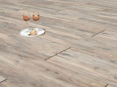 Twee wijnranken en een bloem op houtlook terrastegels