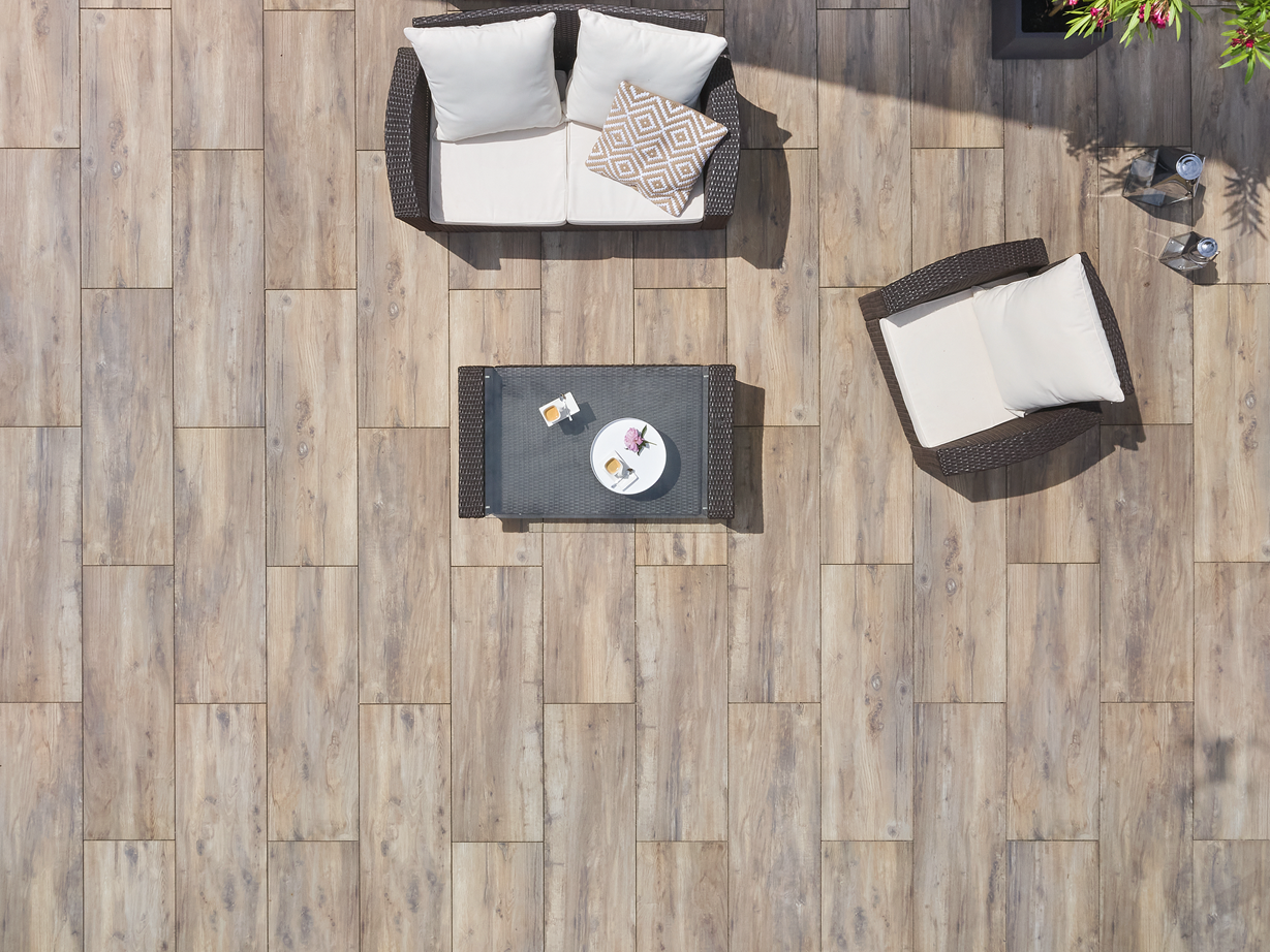 Harmonisch totaaleffect van het gelegde oppervlak Vogelvlucht van een terras met houtlook platen en modern meubilair