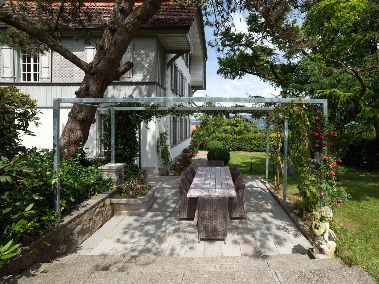 Ein wunderschöner Naturstein für die Terrasse! Terras met natuurstenen platen van grijze zandsteen in een natuurlijke tuin