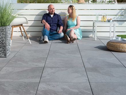 Mensen zittend op terras met platen in lichte alpine grijze leisteen look