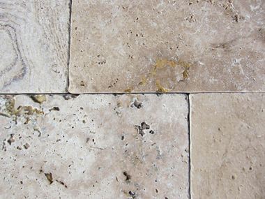 Close-up van getrommelde travertinplaten met karakteristieke inkepingen