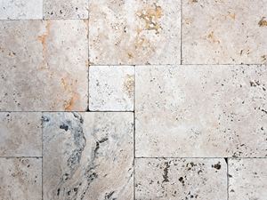 Travertinplaten van boven in een gemengde binding met een levendig kleurenspel in beige- en bruintinten