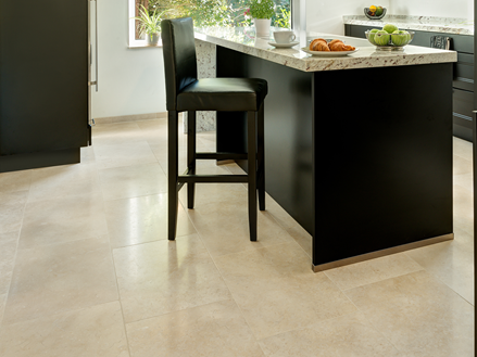 Keuken met moderne zwarte meubels en lichtbeige kalkstenen tegels als vloerbedekking