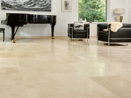 Lichte woonkamer met beige kalkstenen vloeren, moderne banken en een vleugelpiano