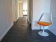 Klantenfoto: Zwarte Rustieke tegels in de gang met witte fauteuil op de voorgrond