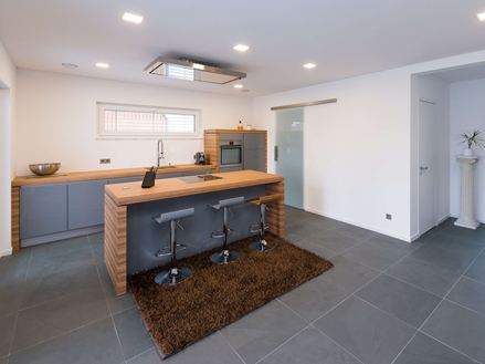 Keuken met houten elementen en leisteentegels in zachtgrijs als vloerbedekking