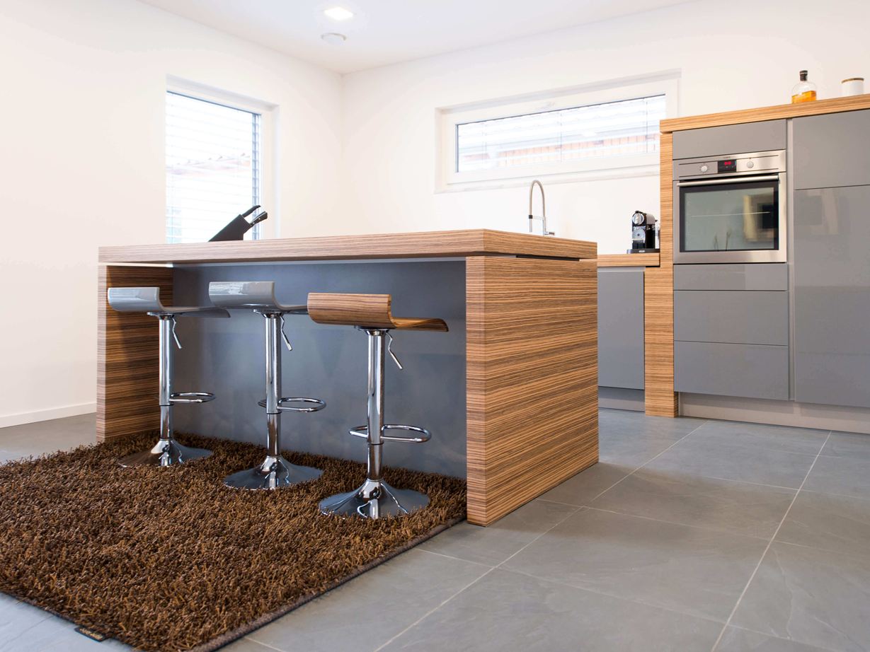 Das große Format wirkt modern. Keuken met open bar, moderne houten elementen en donkere leisteenvloer