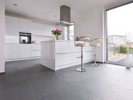 Witte keuken met metalen elementen op grijze leistenen tegel met gedeeld oppervlak