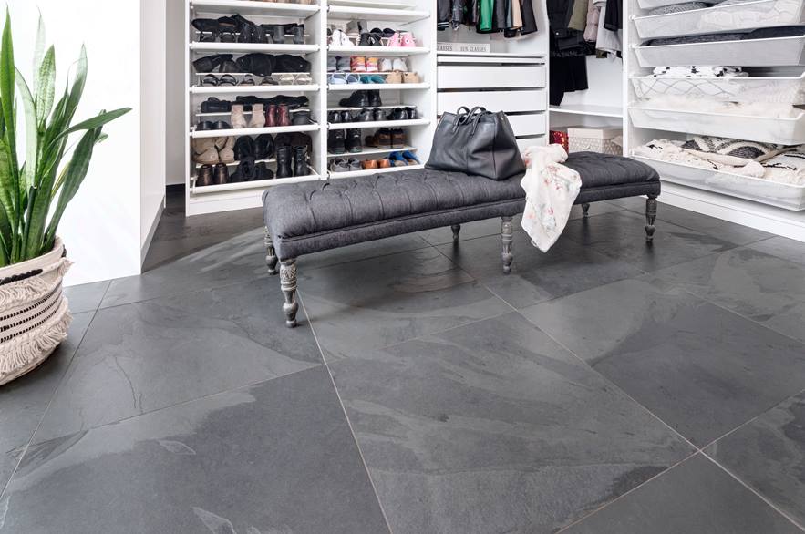 Dressing met grijze bank, witte open kasten en Mustang leistenen tegelvloer