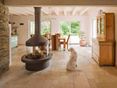 Travertin licht: lichtbeige tinten in zonlicht Lichte tegels in de woonkamer met open haard en hond