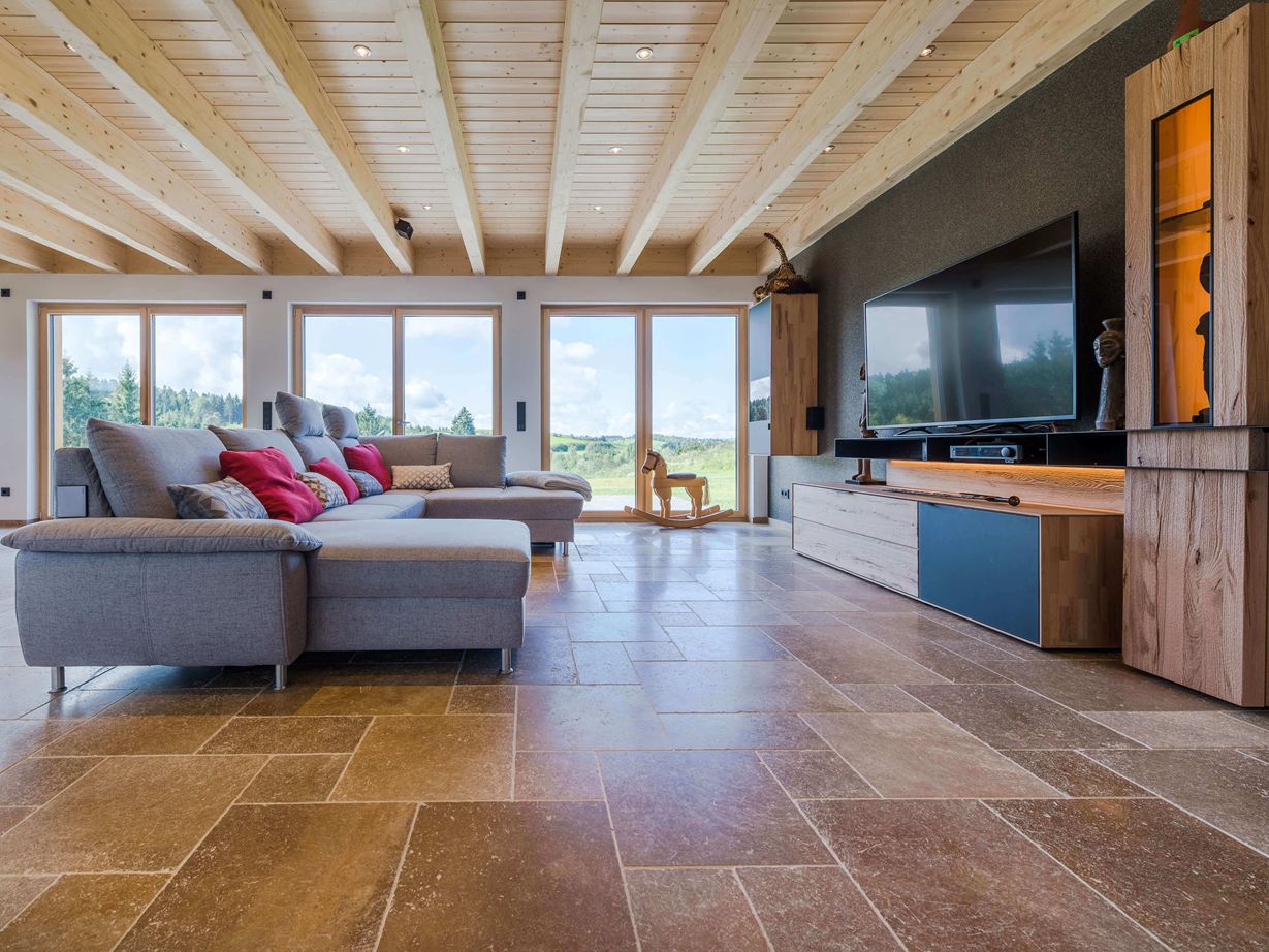 Gezellige flair met notenbruin travertin Woonkamer met grijze bank en walnoot-bruine Noce SELECT travertin tegels