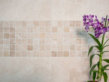Orchidee voor een mozaÃ¯ekmuur met lichtgekleurd travertin