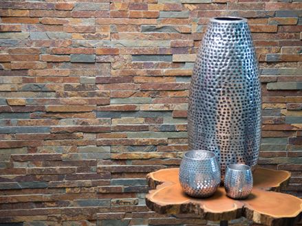 Een grote en twee kleine vazen in zilver voor kleurrijke muur in leisteen