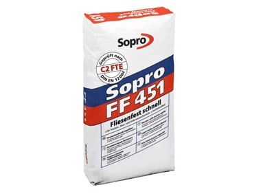 Een zak grijze flexibele lijm voor het leggen van tegels