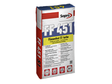 Een zak grijze flexibele lijm voor het leggen van tegels