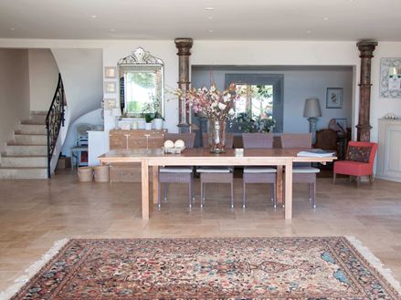 Entree van een hotel met Perzisch tapijt en houten tafel op travertin tegels