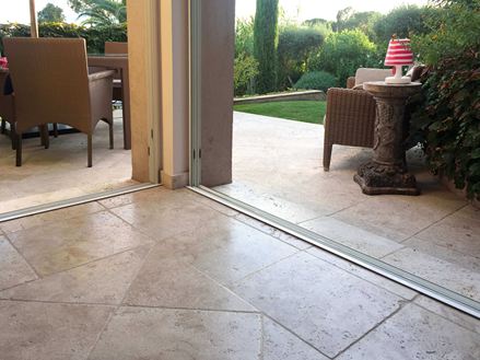 Overgang van binnen naar buiten met beigebruin travertin