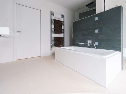 Badkamer met bad en Miros tegels, geborsteld