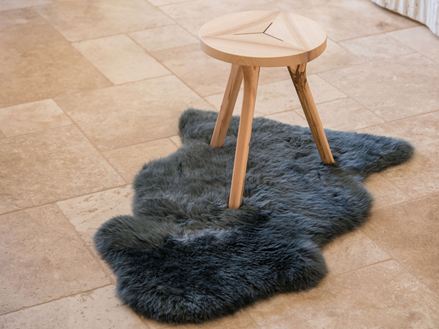 Travertin tegels met houten kruk op drie poten