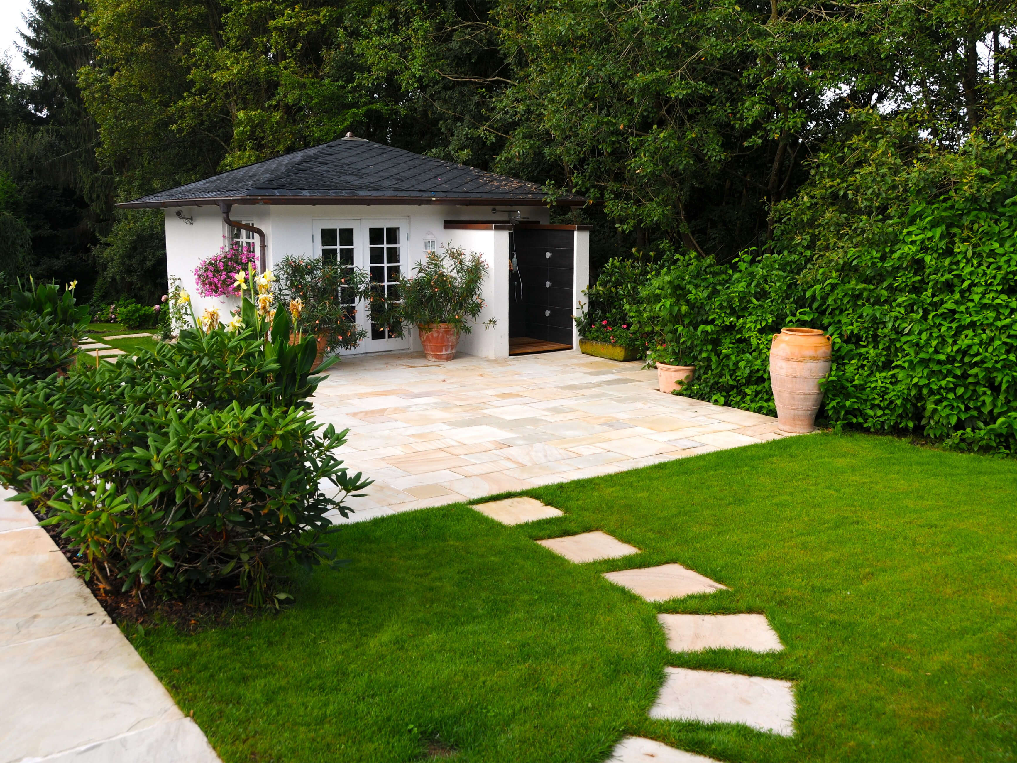 Klantenfoto: platen van gele Mint zandsteen, gelegd als terras en in de tuin als stapstenen