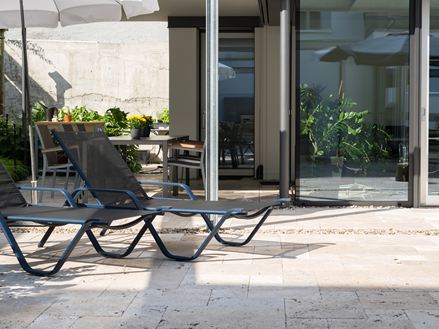 Stijlvolle binnenplaats met travertin en prachtige ligweide