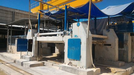 Een loopplankzaag zaagt een ruw blok steen in zogenaamde "plakken".