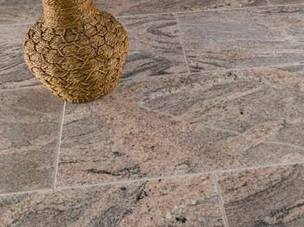 Juparana Colombo tegels in rood-grijs met een bruine decoratieve vaas