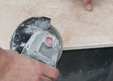 Een stenen plaat wordt gezaagd met een hoekfrees